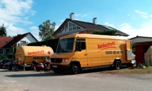 Gelber Tank steht neben gelben Kastenfahrzeug vor Wohnhaus_boerger-tankservice
